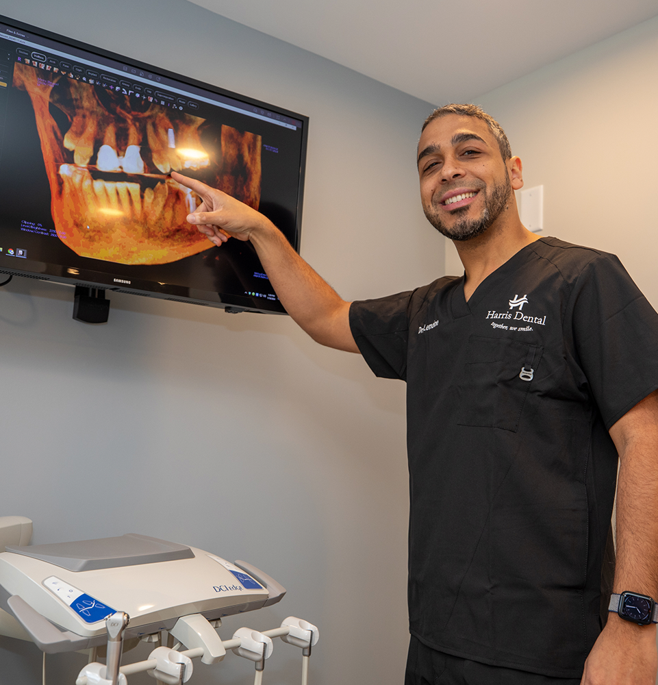 Dr. Lomine pointing to a digital x-ray of an implant