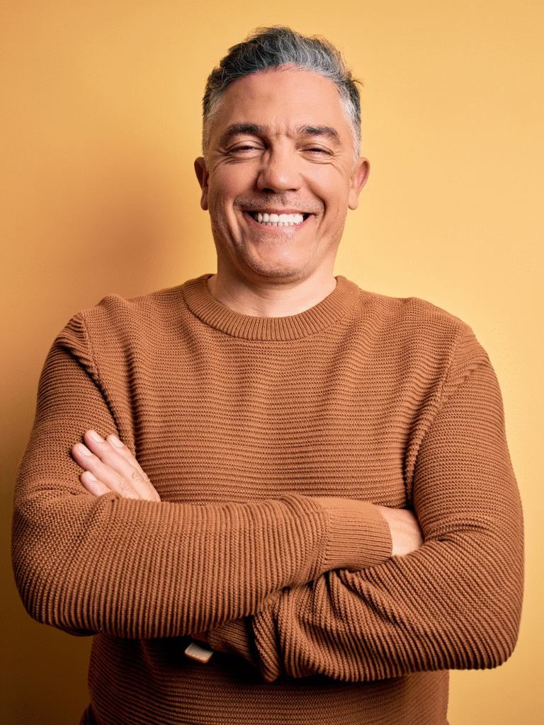 Middle aged man smiling with arms crossed